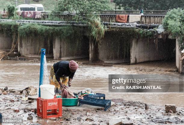 Woman continues with her chores at the Quarry road informal settlement outside Durban on April 18, 2022 as rain begins to fall once again after...