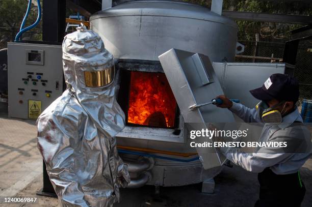 Police wearing heat reflecting clothing incinerates a bag of seized cocaine at a police base in Lima on April 18, 2022. - Peru's anti-narcotics...