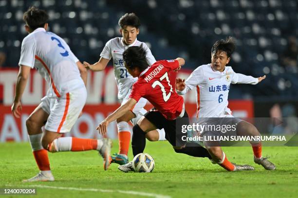 Japans Urawa Reds Kai Matsuzaki fights for the ball with Chinas Shandong Taishan Chen Zhexuan and Lin Guoyu during the AFC Champions League Group F...