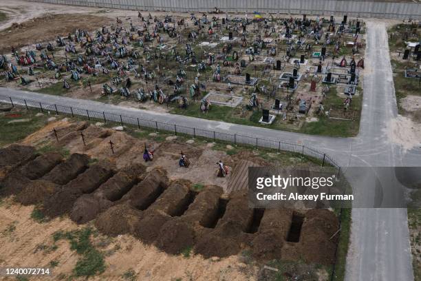 Freshly dug graves are seen at the cemetery on April 18, 2022 in Bucha, Ukraine.