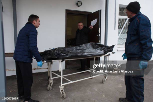 The funeral services workers bring the bodies to the morgue on April 18, 2022 in Bucha, Ukraine. The Russian retreat from Ukrainian towns and cities...