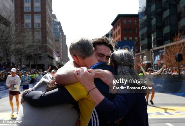 Boston, MA The Richard family - Jane, Bill and Denise embrace Henry Richard after he crosses the finish line of the 126th Boston Marathon in Boston...