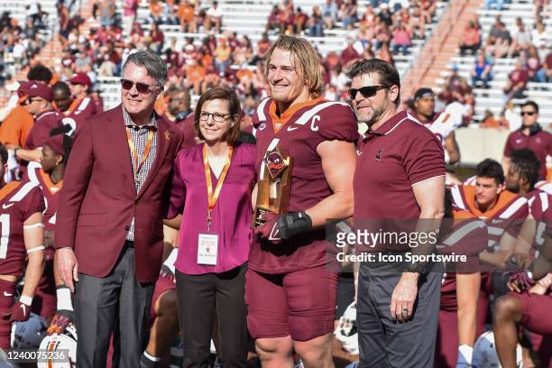 Virginia Tech Hokies linebacker Dax Hollifield receives the Presidents Leadership Award from Head Coach Brent Pry and University President Tim Sands...