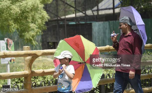 Visitors carry umbrellas on a hot summer day at Delhi Zoo on April 18, 2022 in New Delhi, India.