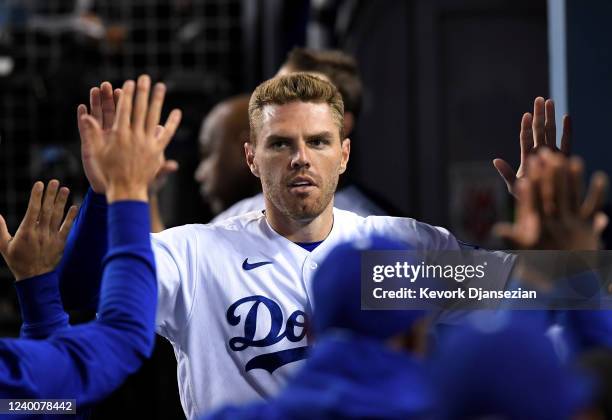 Freddie Freeman of the Los Angeles Dodgers is congratulated after scoring a run on three run double by teammate Trea Turner against relief pitcher...