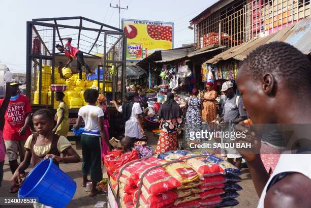 Traders are seen at the Lumley Market in Freetown on April 9 prices for food, fuel and gas has surged in Sierra Leone due to the disruption of the...