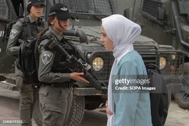 Palestinian student walk in front of the Israeli security forces as they protect Jewish settlers who visit the ancient village of Sebastia on the...