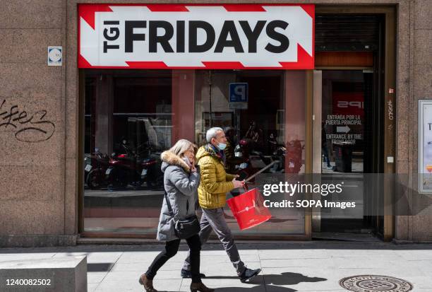 Pedestrians walk past the American casual dining restaurant chain TGI Fridays in Spain.