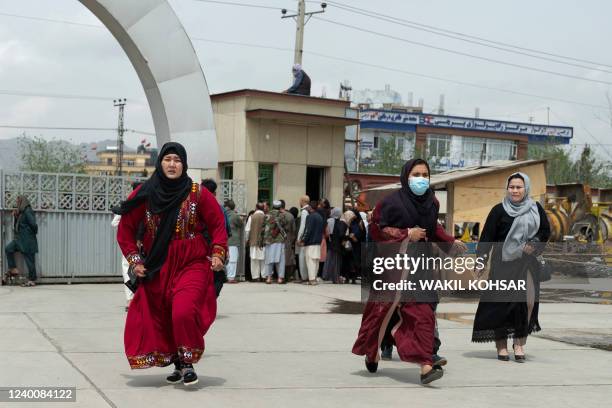Relatives of victims arrive to search for their loved ones outside a hospital in Kabul on April 19 after two bomb blasts rocked a boys' school in a...