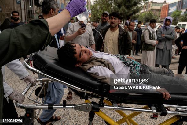 Medical staff move a wounded youth on a stretcher outside a hospital in Kabul on April 19 after two bomb blasts rocked a boys' school in a Shiite...