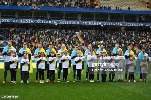 Shakhtar Donetsk's players bearing Ukrainian flags listen to a national anthem before their "Global Tour for Peace" friendly charity football match...