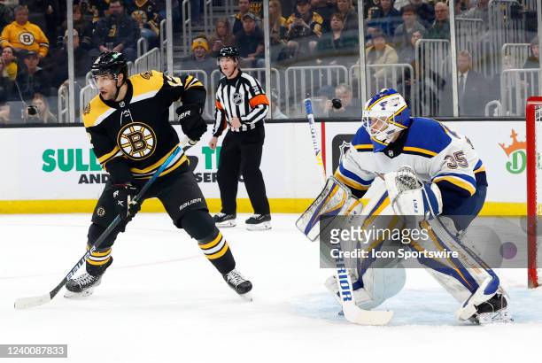 Boston Bruins center Craig Smith sets up in front of St. Louis Blues goalie Ville Husso during a game between the Boston Bruins and the St. Louis...