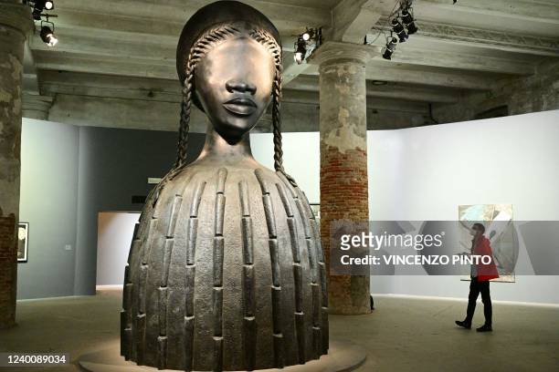 Visitor views "Brick House", a 2019 bronze sculpture by artist Simone Leigh, during a press day at the 59th Venice Art Biennale in Venice on April...