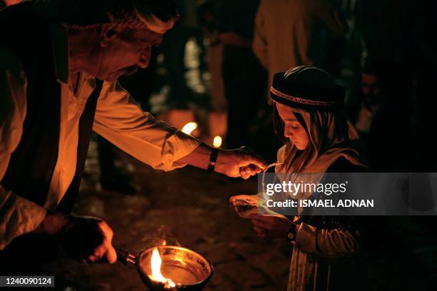 Iraqi Yazidis light candles outside the Temple of Lalish in a valley near the Kurdish city of Dohuk on April 19 during a ceremony marking the Yazidi...