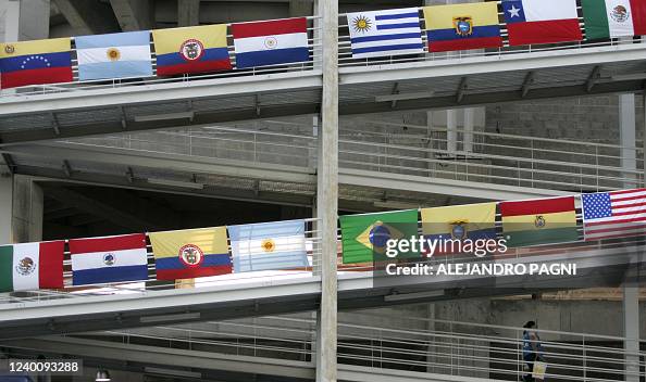 Flag Ramp A woman walks by a ramp decorated with the flags of the countries ...