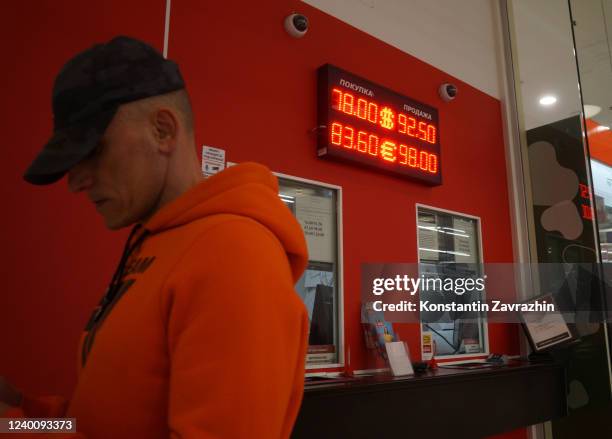 Man walks past to the exchange office with rates of U.S. Dollar and Euro to Russian Ruble seen at the panel, April 2022, in Moscow, Russia. German...
