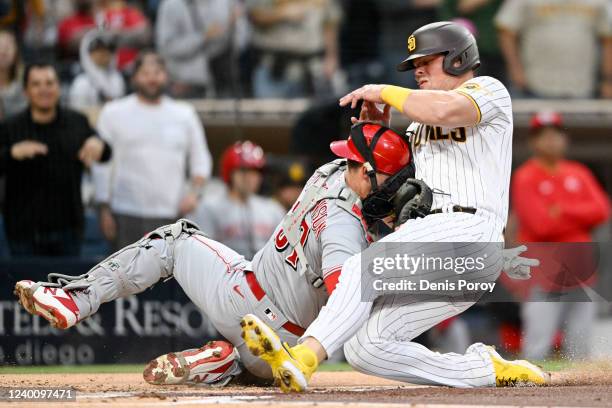 Luke Voit of the San Diego Padres collides with Tyler Stephenson of the Cincinnati Reds at home plate during the second inning of a baseball game at...