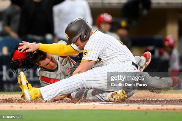 Luke Voit of the San Diego Padres collides with Tyler Stephenson of the Cincinnati Reds at home plate during the second inning of a baseball game at...