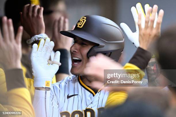 Manny Machado of the San Diego Padres is congratulated in the dugout after hitting a two-run home run during the first inning of a baseball game...