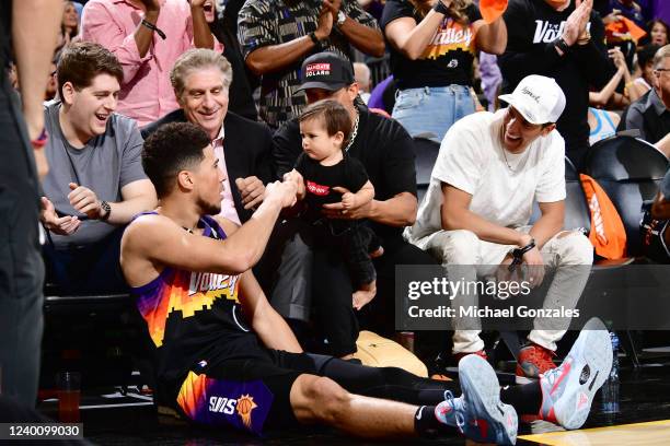 Devin Booker of the Phoenix Suns high fives a fan during Round 1 Game 2 of the 2022 NBA Playoffs on April 19, 2022 at Footprint Center in Phoenix,...