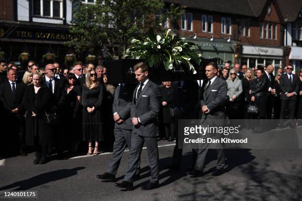 The coffin is lifted from a horse-drawn hearse before a funeral service for Tom Parker at St Francis of Assisi church on April 20, 2022 in Orpington,...