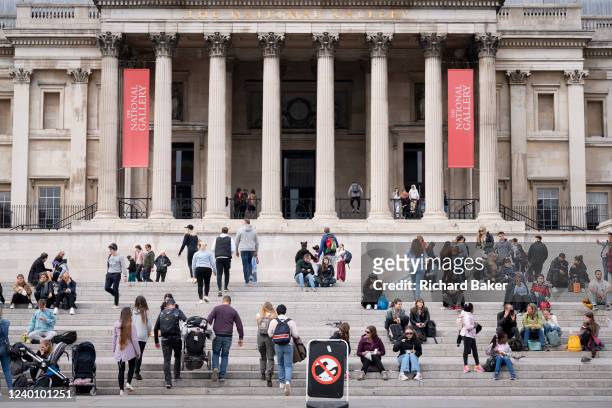 Crowds of families and visitors to the capital enjoy spring temperatures outside the National Gallery in Trafalgar Square, on 19th April 2022, in...
