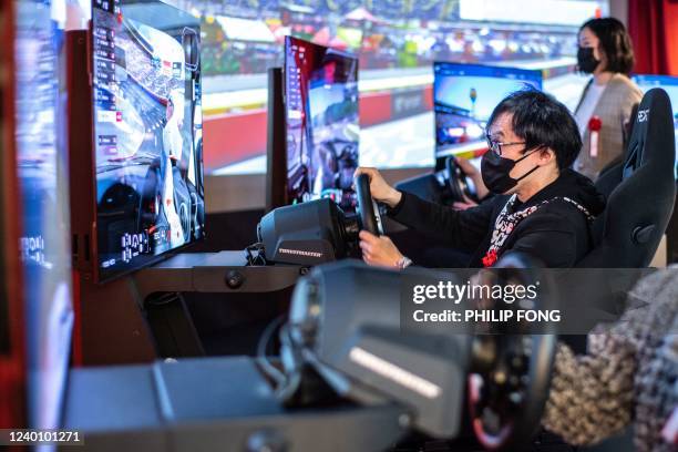 Guests play motor racing games at the Red E-Motor area during a media preview of the Red° Tokyo Tower esports park in Tokyo on April 20, 2022.