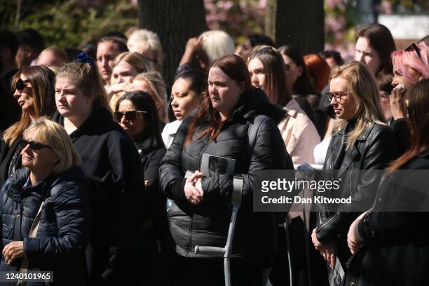 Fans mourn as they watch the funeral service for Tom Parker on screens outside St Francis of Assisi church on April 20, 2022 in Orpington, England....
