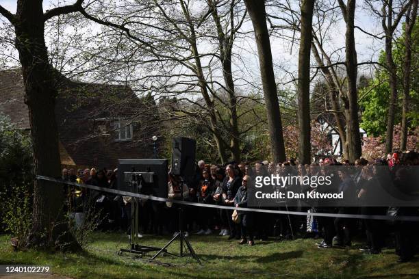Fans watch the funeral service for Tom Parker on screens outside St Francis of Assisi church on April 20, 2022 in Orpington, England. British singer...