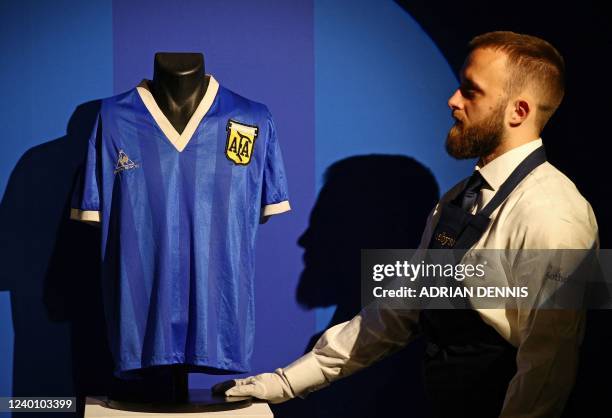 Sotheby's technician adjusts a football shirt worn by Argentina's Diego Maradona during the 1986 World Cup quarter-final match against England,...