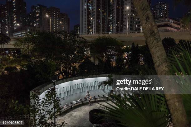 Man sits in a park with some benches cordoned off due to Covid-19 social distancing measures in Hong Kong on April 20, 2022.