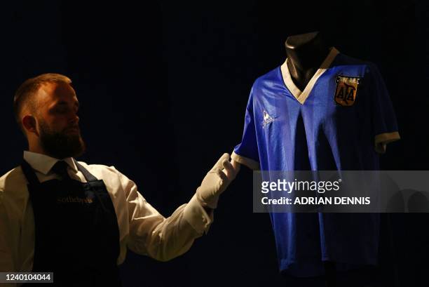 Sotheby's technician adjusts a football shirt worn by Argentina's Diego Maradona during the 1986 World Cup quarter-final match against England,...