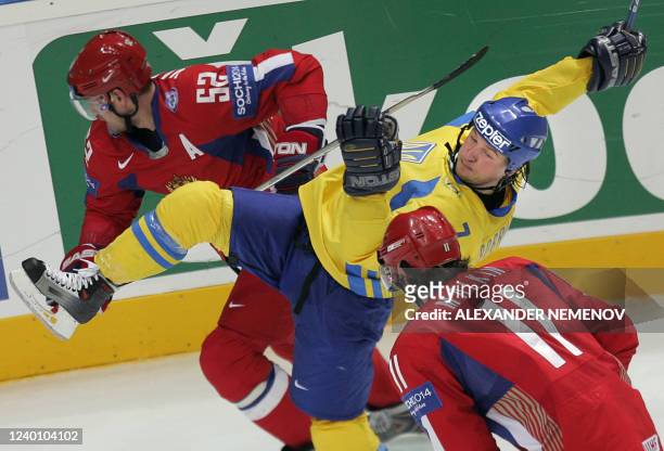 Russians Andrey Markov and Evgeni Malkin send Ukrainian Vasyl Bobrovnikov down during the preliminary round group D game of the IIHF Internetional...