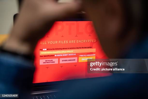 February 2022, North Rhine-Westphalia, Bad Oeynhausen: A man sits in front of a laptop infected with a fictitious encryption Trojan . In attacks with...