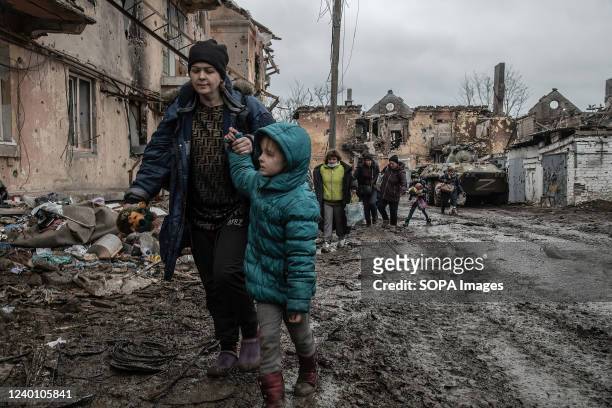 Civilians walk through a destroyed neighborhood in Eastern Mariupol that has recently come under control of Russia/ pro-Russian forces. The battle...