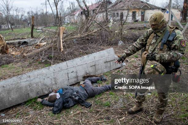 Russian soldier points at bullet holes in the back of a civilian he says was shot by retreating Ukrainian forces. The battle between Russian / Pro...