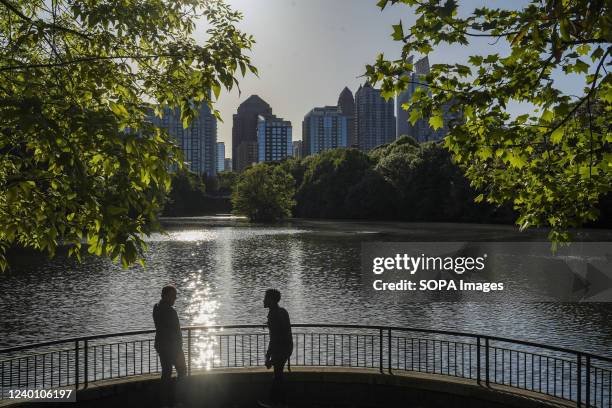 Men enjoy the view as the sun sets at Piedmont park in Atlanta.