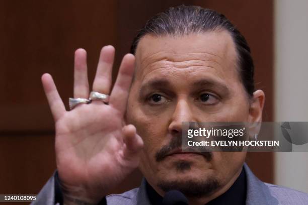 Actor Johnny Depp displays the middle finger of his hand, injured while he and his ex-wife Amber Heard were in Australia in 2015, as he testifies...