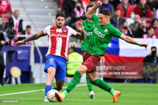 Atletico Madrid's Argentinian midfielder Rodrigo De Paul fights for the ball with Granada's Serbian midfielder Njegos Petrovic during the Spanish...