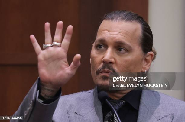 Actor Johnny Depp displays the middle finger of his hand, injured while he and his ex-wife Amber Heard were in Australia in 2015, as he testifies...