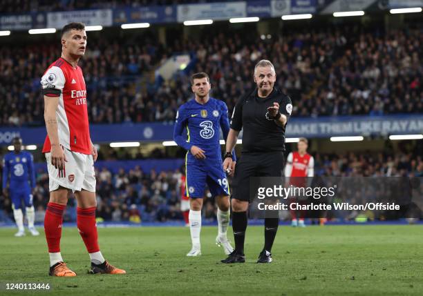 Granit Xhaka of Arsenal and referee Jonathan Moss during the Premier League match between Chelsea and Arsenal at Stamford Bridge on April 20, 2022 in...