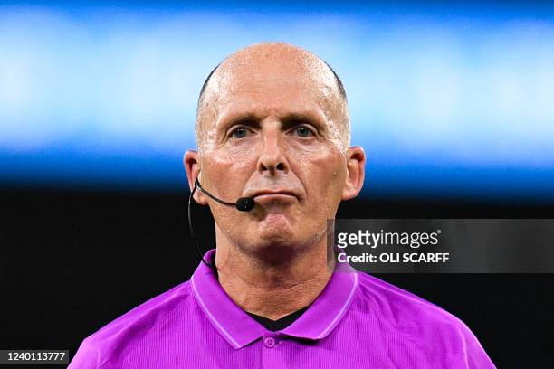 English referee Mike Dean reacts during the English Premier League football match between Manchester City and Brighton and Hove Albion at the Etihad...