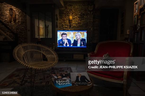 Cat sits in an armchair, April 20 in Givors, near Lyon, as a TV screen displays the live televised debate between French President and La Republique...