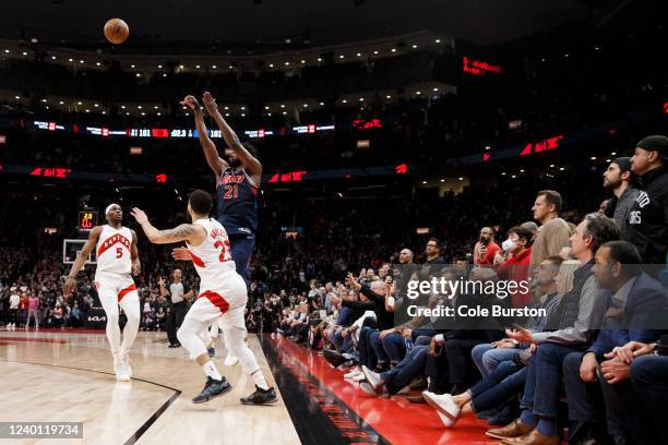 Joel Embiid of the Philadelphia 76ers puts up a shot over Precious Achiuwa and Fred VanVleet of the Toronto Raptors in the final seconds of overtime...