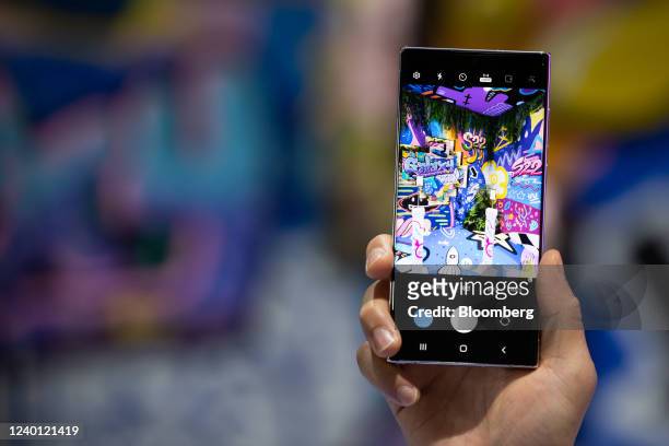 An employee demonstrates a Samsung Electronics Co. Galaxy S22 Ultra 5G smartphone at the World IT Show 2022 in Seoul, South Korea, on Thursday, April...