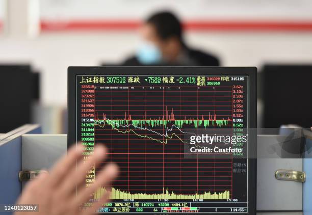 Investors pay attention to the stock market at a securities office in Fuyang city, East China's Anhui Province, April 21, 2022.