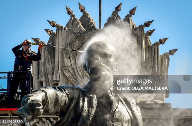 Worker cleans a statue of the founder of the Soviet Union Vladimir Lenin at Moscow Square in front of the House of Soviets in Saint-Petersburg on...