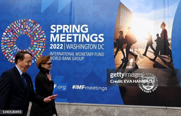People walk past the International Monetary Fund headquarters in Washington, DC on April 21, 2022. - The 2022 Spring Meetings of the World Bank Group...