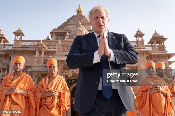 Shoeless UK prime minister Boris Johnson walks with sadhus, Hindu holymen, as he visits the Swaminarayan Akshardham temple during his two day trip to...