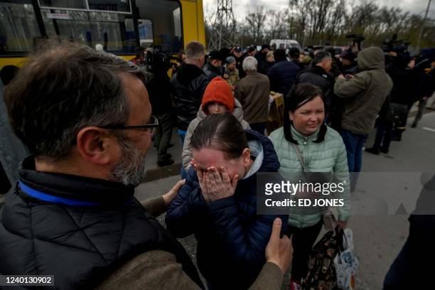 People fleeing fighting in the southern city of Mariupol meet with relatives and frieds as they arrive in a small convoy that crossed through...